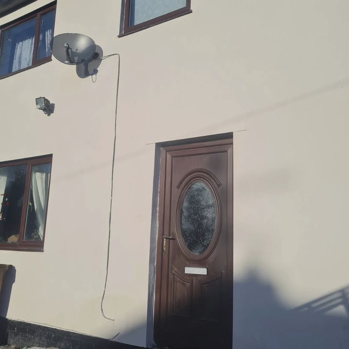 Cream render around a front door and windows