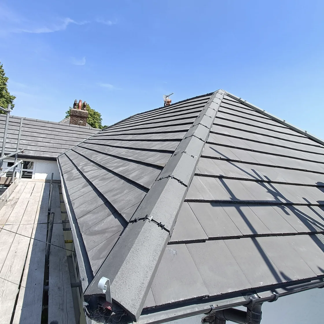 Finished grey tiled roof with hip and valley