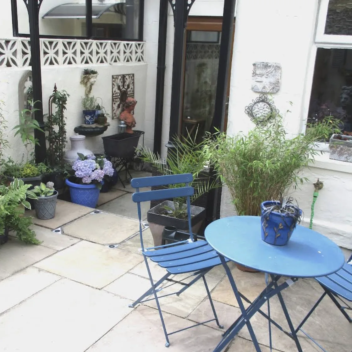 Paved courtyard with blue garden furniture
