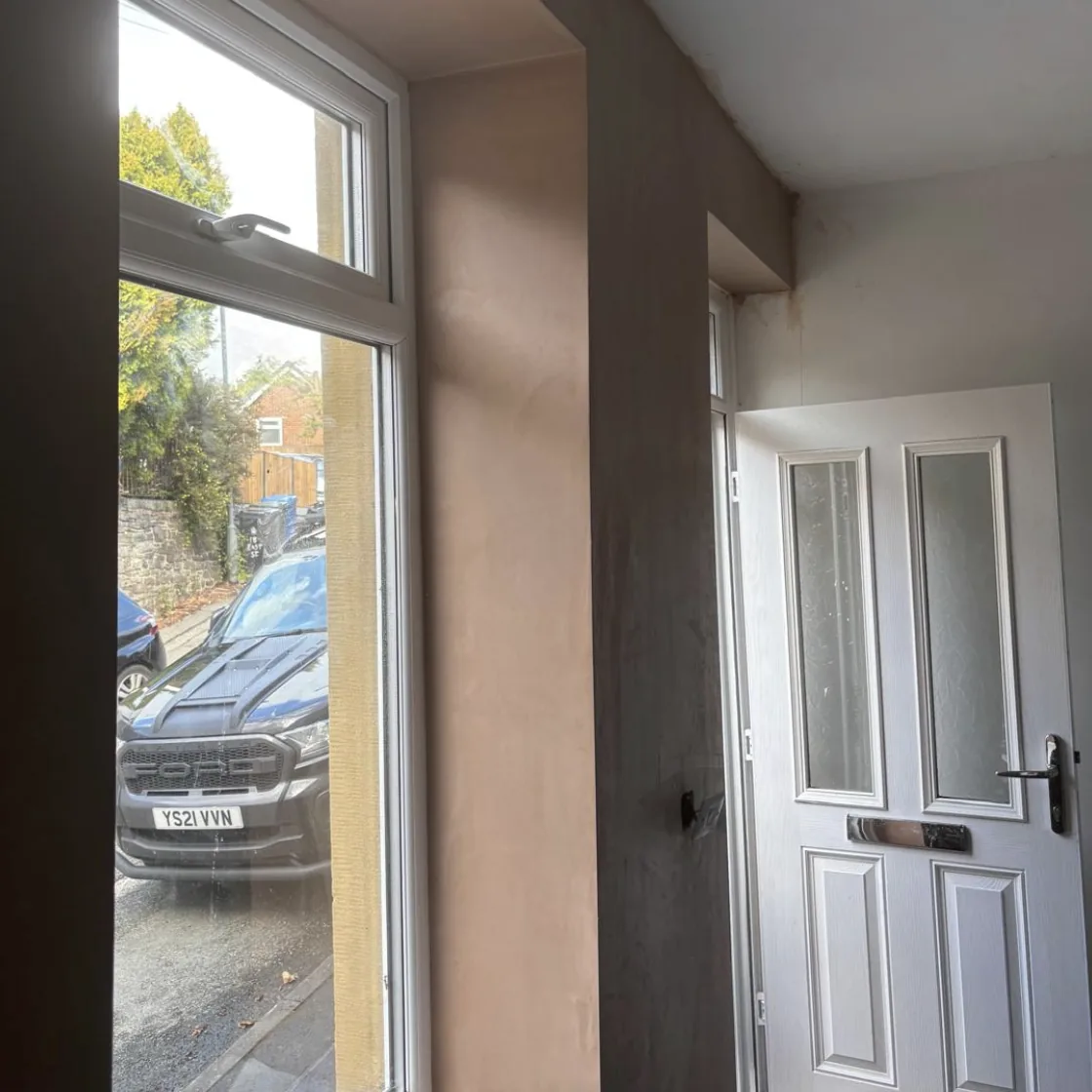 Fresh plaster around a window and entrance door