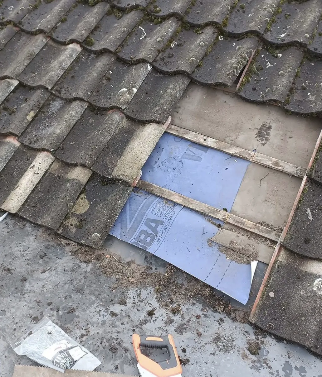 Lifted roof tiles exposing membrane and battens during a repair