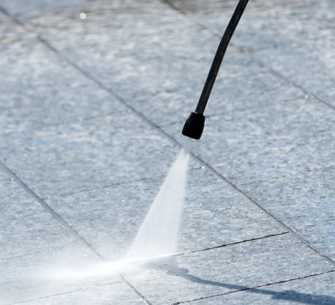 Pressure washer cleaning a paved surface