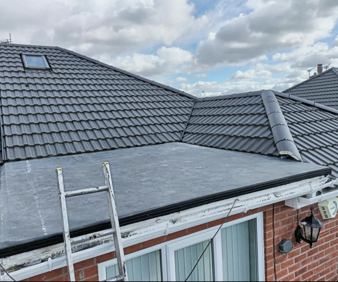 Flat roof meeting grey pitched roof tiles